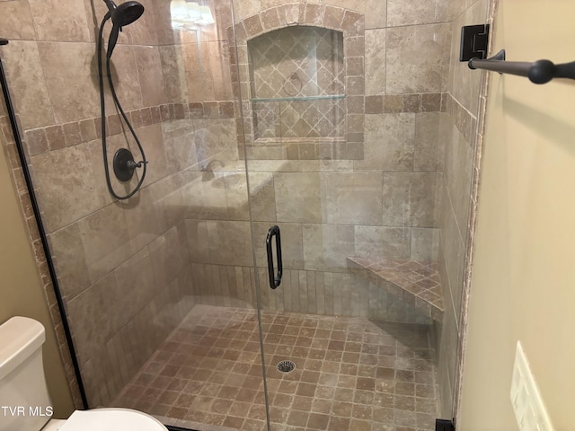 bathroom with a shower stall and toilet