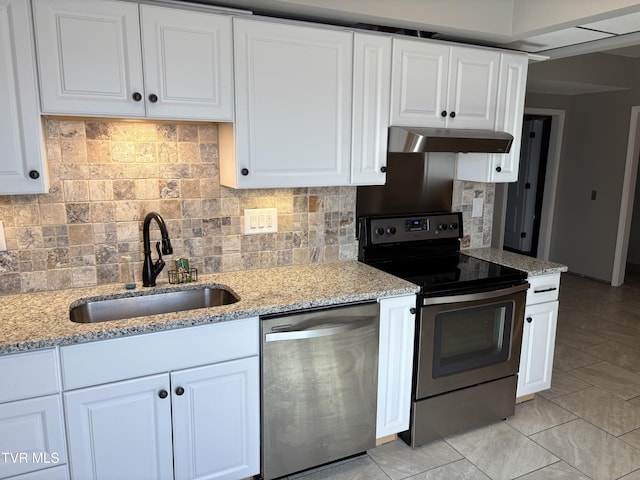 kitchen featuring light stone counters, under cabinet range hood, a sink, white cabinets, and appliances with stainless steel finishes