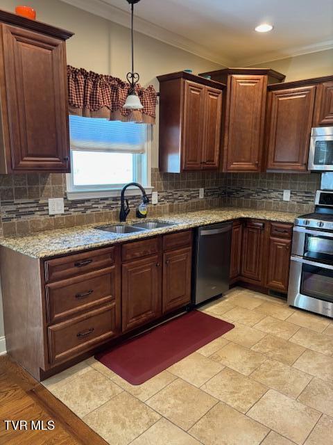 kitchen with crown molding, decorative backsplash, stainless steel appliances, and a sink