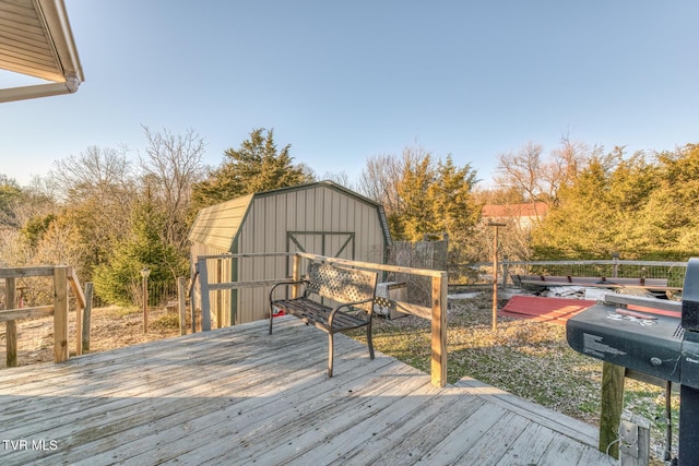 deck with an outbuilding, a storage unit, and fence