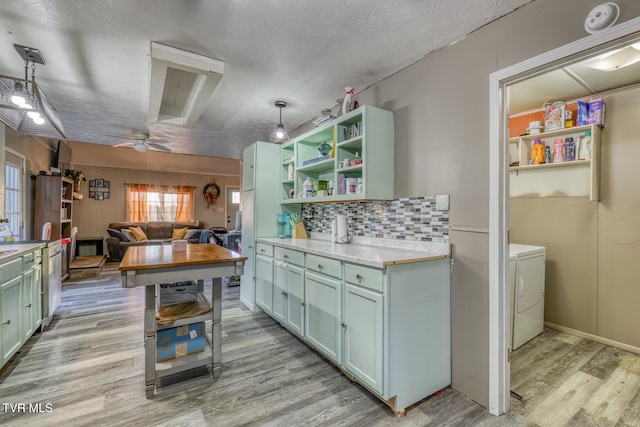 kitchen featuring light wood finished floors, open shelves, tasteful backsplash, light countertops, and washer / dryer