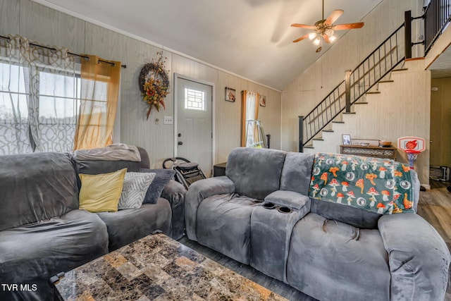 living area featuring lofted ceiling, stairs, a ceiling fan, and wood finished floors