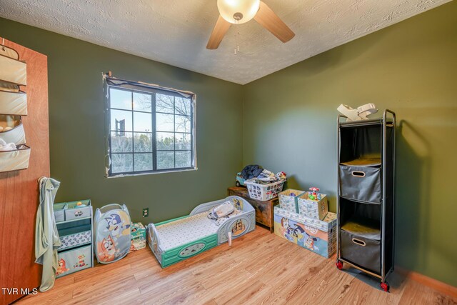 bedroom featuring ceiling fan, a textured ceiling, and wood finished floors