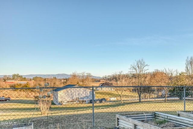 view of yard featuring fence and a mountain view