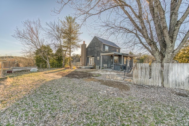 exterior space featuring a chimney and fence