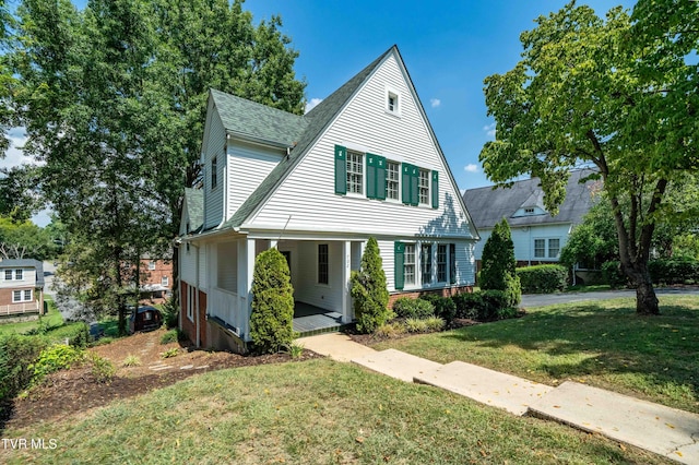 view of front of home with a porch, a front yard, and a shingled roof