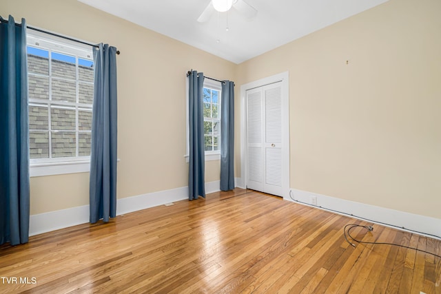 spare room with light wood-type flooring, baseboards, and a ceiling fan