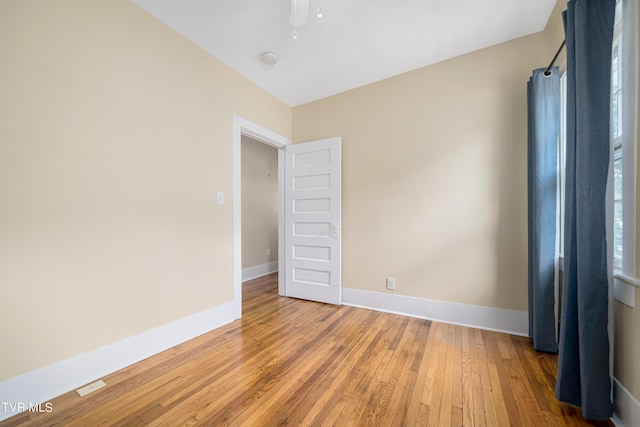 spare room featuring hardwood / wood-style flooring and baseboards