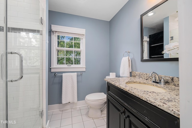 bathroom featuring a stall shower, vanity, baseboards, and tile patterned floors