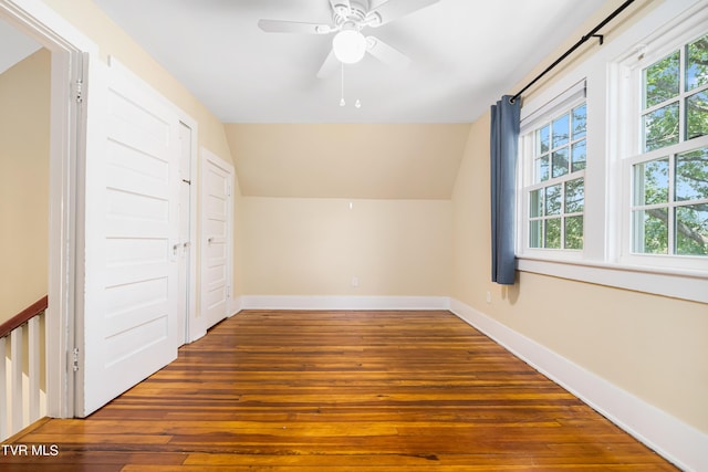 additional living space featuring vaulted ceiling, a ceiling fan, hardwood / wood-style flooring, and baseboards