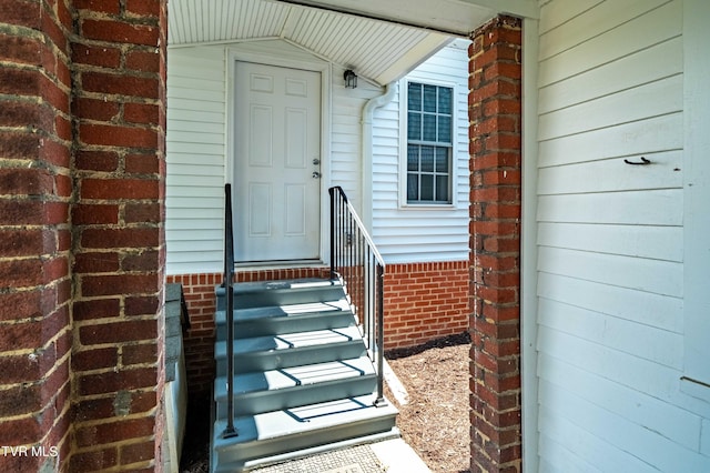 view of exterior entry with brick siding