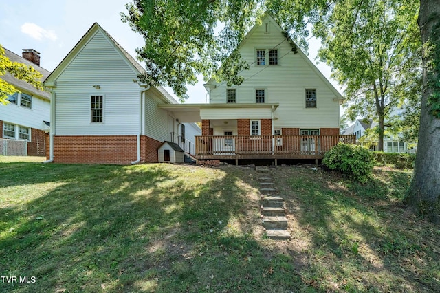 rear view of house with brick siding, a yard, and a wooden deck