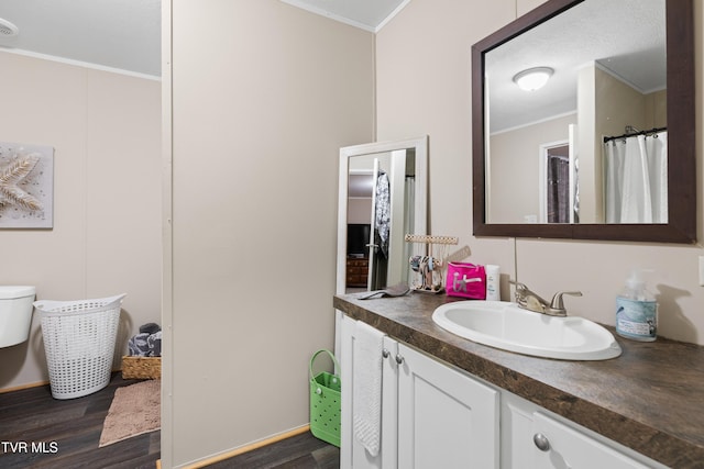 bathroom featuring crown molding, vanity, and wood finished floors