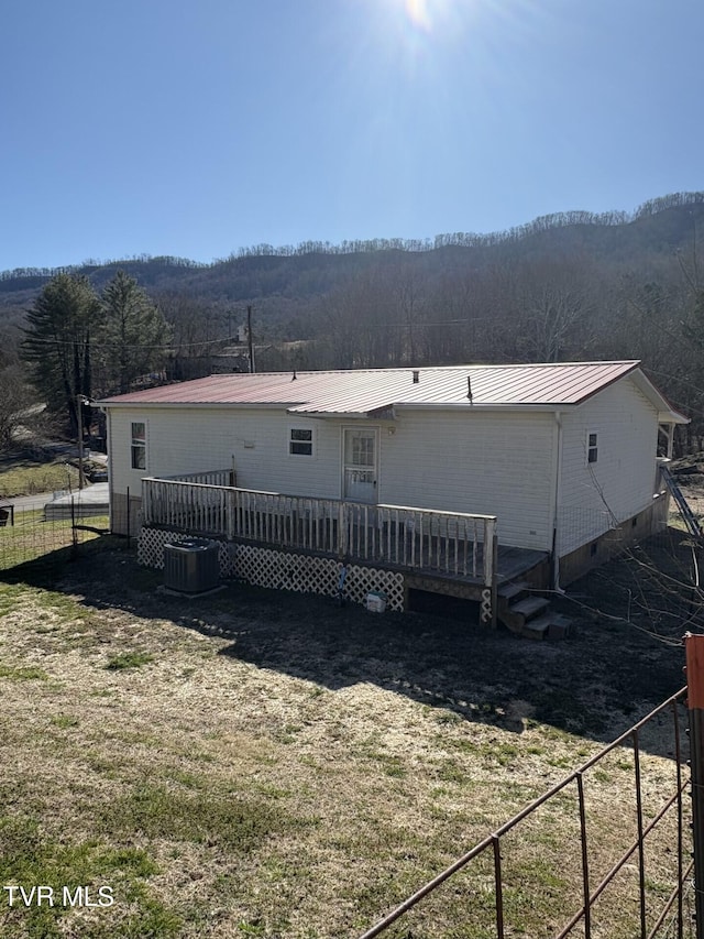 rear view of property with metal roof, crawl space, fence, a wooden deck, and central air condition unit