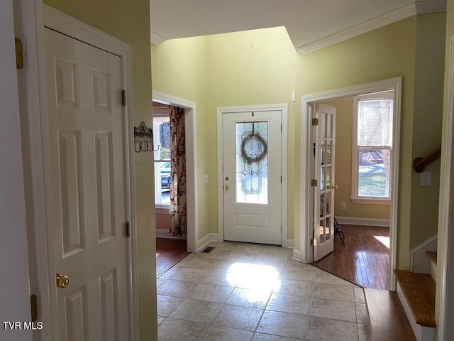 entrance foyer featuring crown molding, baseboards, and light tile patterned floors