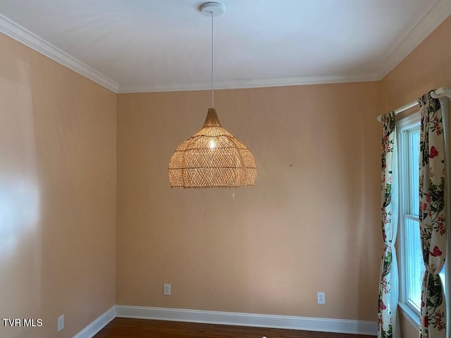 empty room with dark wood-style floors, baseboards, and crown molding