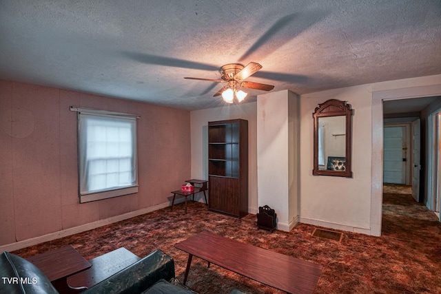 unfurnished living room with ceiling fan, baseboards, and a textured ceiling