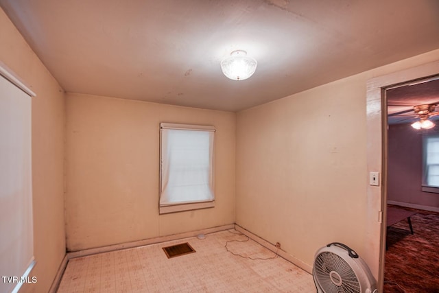 spare room featuring baseboards, visible vents, and tile patterned floors