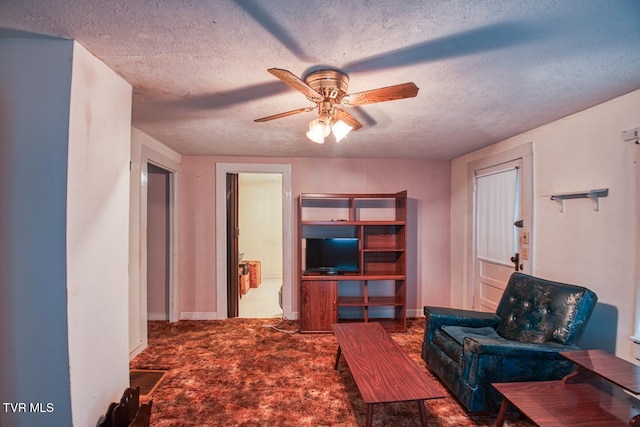 living room with carpet floors, a ceiling fan, and a textured ceiling