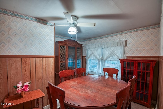 dining room featuring a ceiling fan and wallpapered walls