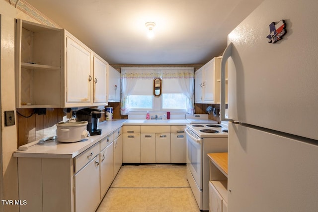 kitchen with white appliances, white cabinetry, open shelves, and light countertops