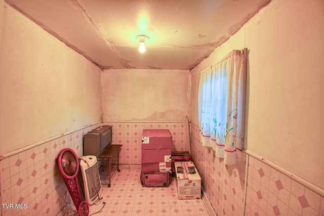 interior space featuring wainscoting, tile walls, and tile patterned floors