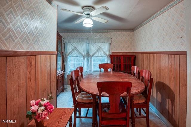 dining room with a ceiling fan and wallpapered walls