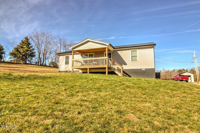 back of house featuring a deck and a lawn