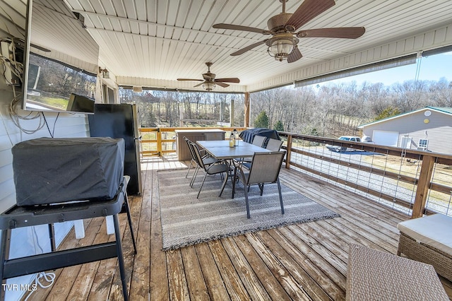 wooden terrace featuring outdoor dining space and ceiling fan