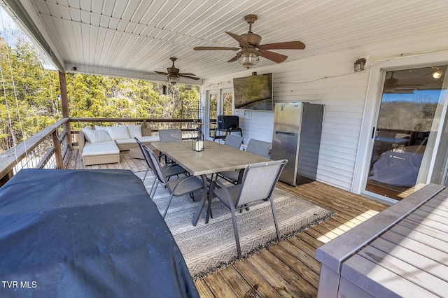 wooden deck featuring an outdoor hangout area, ceiling fan, and outdoor dining space