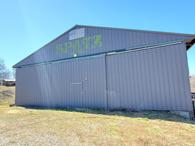 exterior space with a pole building, an outdoor structure, and a lawn