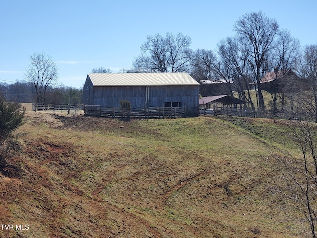 view of yard with an outbuilding, a rural view, fence, and an outdoor structure