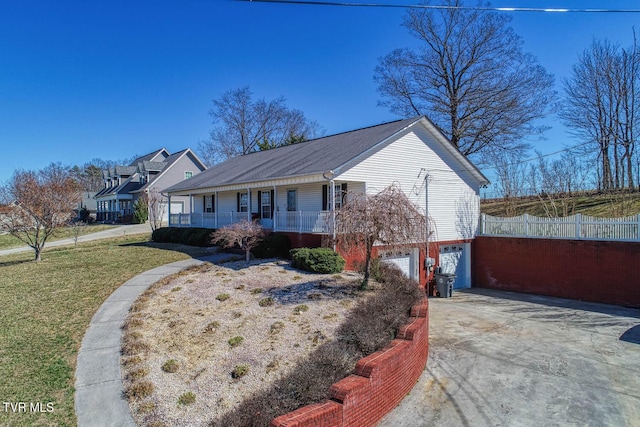 ranch-style house featuring a porch, a front yard, fence, a garage, and driveway