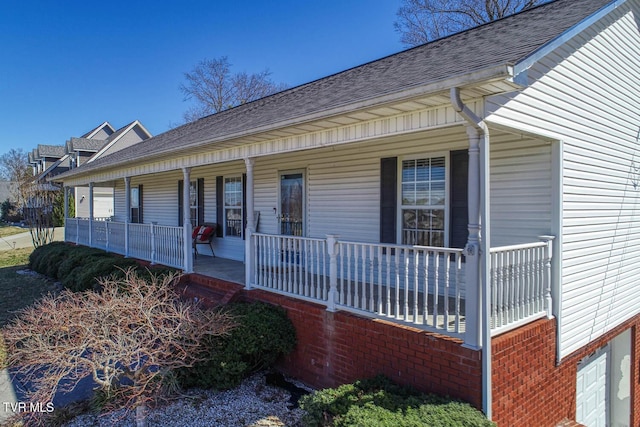 view of front of house with covered porch and a shingled roof