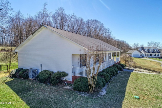 view of side of property featuring a shingled roof, covered porch, a yard, and central air condition unit