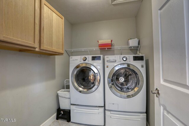 laundry area with cabinet space, independent washer and dryer, and baseboards