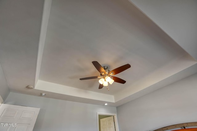 room details featuring ceiling fan and a tray ceiling