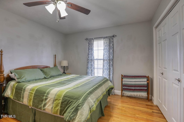 bedroom featuring ceiling fan, a closet, baseboards, and light wood-style floors