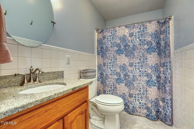 full bath featuring toilet, vanity, tile walls, and tile patterned floors