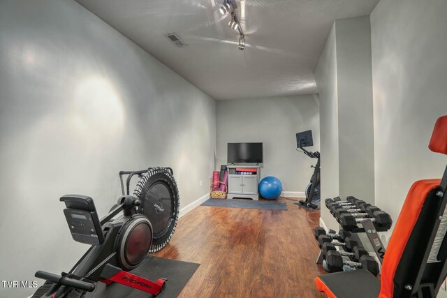 exercise area featuring wood finished floors and baseboards