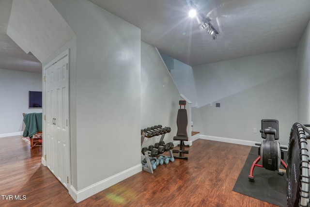 workout room featuring baseboards and wood finished floors