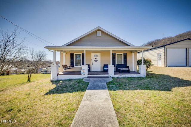 bungalow-style home featuring covered porch, an outbuilding, and a front yard