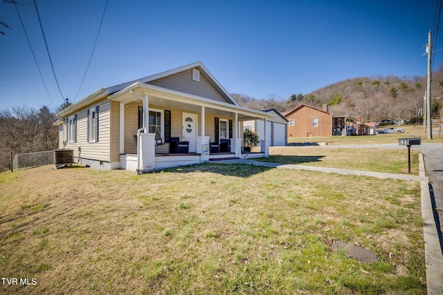 bungalow-style house featuring central air condition unit, covered porch, an outdoor structure, crawl space, and a front yard