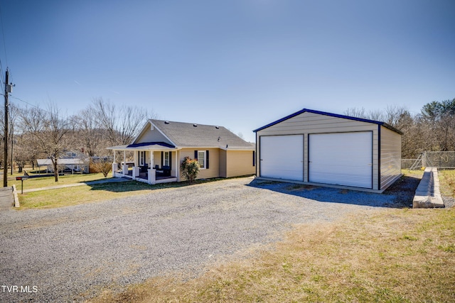 view of front of property featuring an outbuilding, a detached garage, and a front lawn