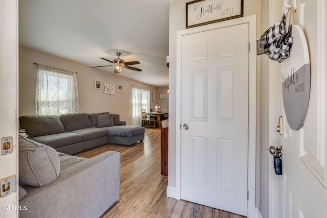 living area with a ceiling fan and wood finished floors