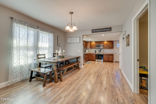 dining room featuring light wood-style flooring and baseboards