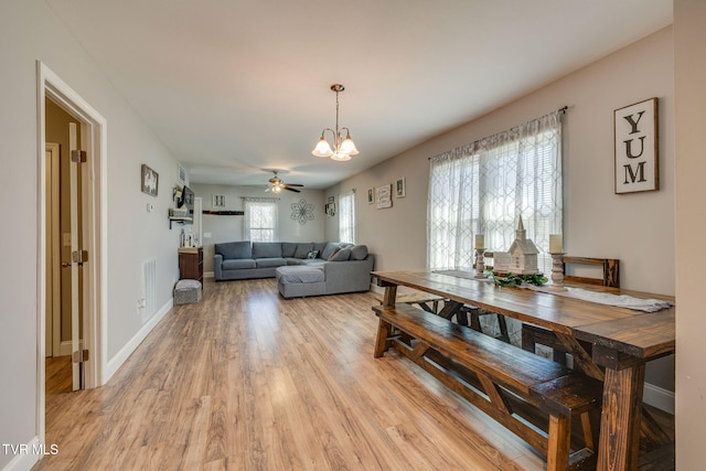 dining room with a chandelier, light wood-style floors, and baseboards