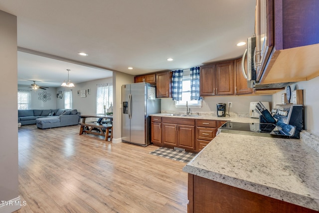 kitchen with light wood finished floors, stainless steel appliances, light countertops, and brown cabinetry