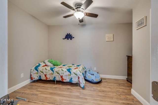 bedroom featuring ceiling fan, baseboards, and wood finished floors