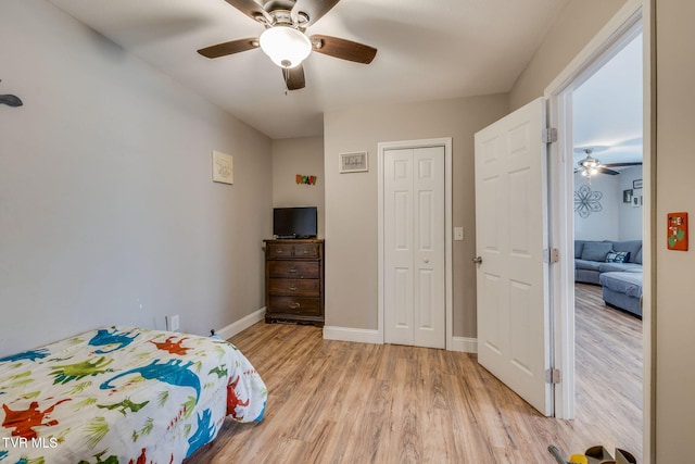 bedroom featuring baseboards, a closet, a ceiling fan, and light wood-style floors